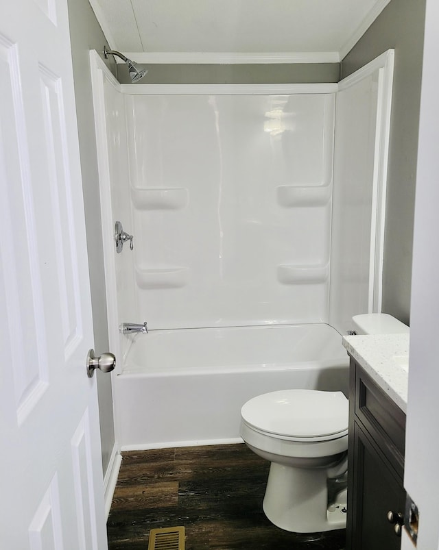 full bathroom featuring toilet, hardwood / wood-style floors, ornamental molding, tub / shower combination, and vanity