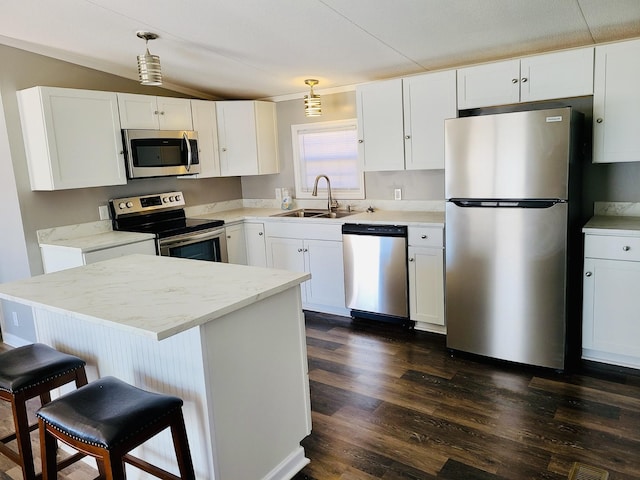 kitchen with sink, hanging light fixtures, dark wood-type flooring, stainless steel appliances, and white cabinets