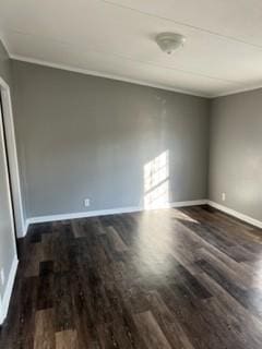 spare room featuring dark wood-type flooring and crown molding