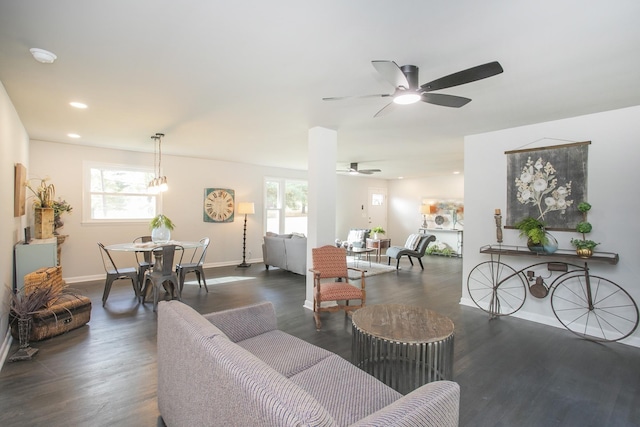 living room with dark wood-type flooring and ceiling fan