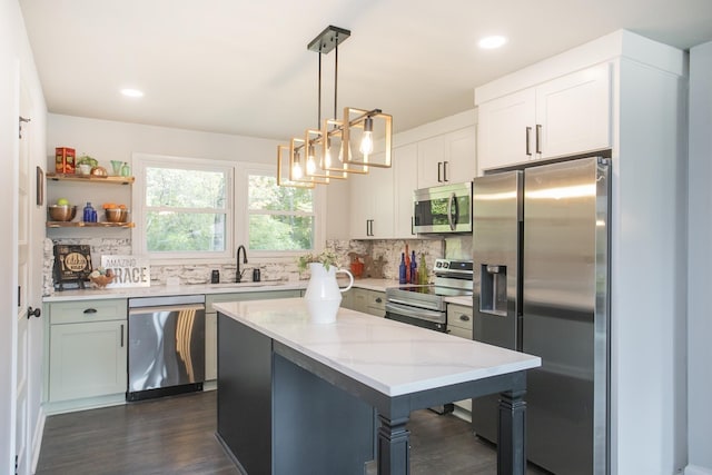 kitchen featuring white cabinetry, sink, decorative backsplash, hanging light fixtures, and stainless steel appliances