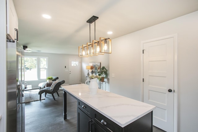 kitchen with stainless steel fridge, dark hardwood / wood-style floors, a kitchen island, pendant lighting, and ceiling fan