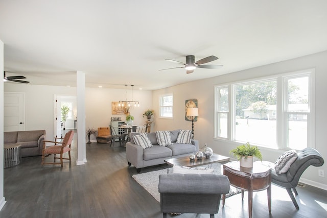 living room with ceiling fan with notable chandelier and dark wood-type flooring