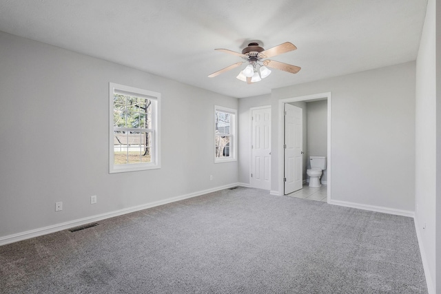 unfurnished bedroom with ceiling fan, connected bathroom, and light carpet