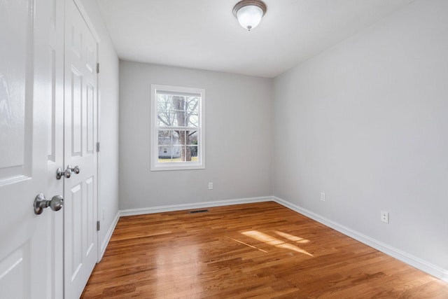 empty room with hardwood / wood-style flooring