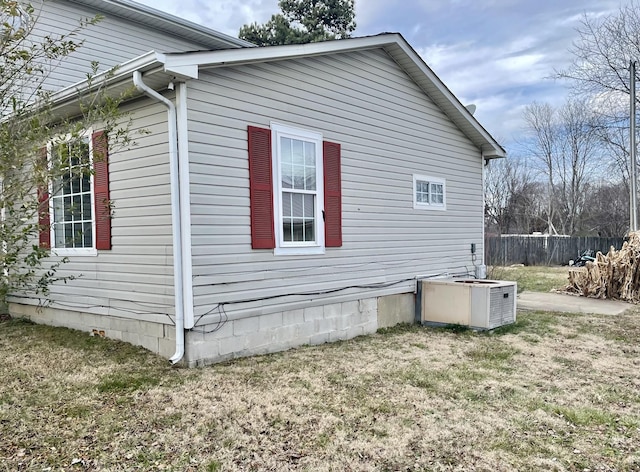 view of home's exterior featuring central AC unit and a yard