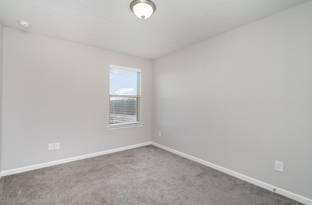 carpeted empty room featuring a textured ceiling