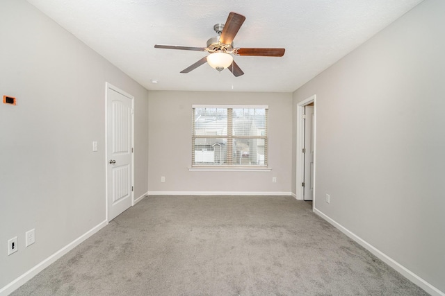 carpeted spare room featuring ceiling fan