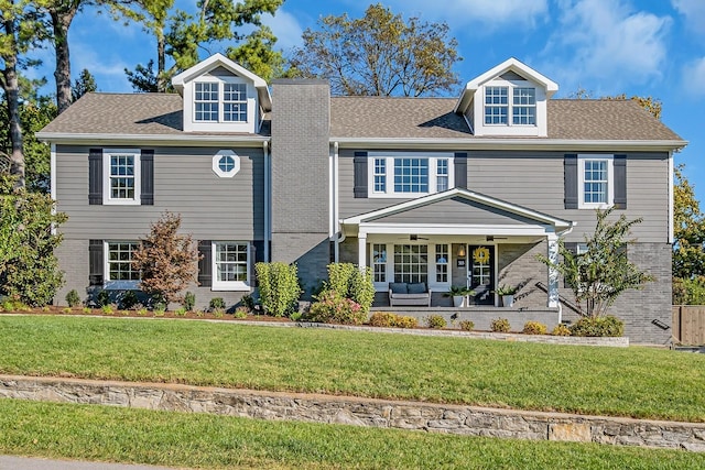 view of front facade with ceiling fan and a front lawn