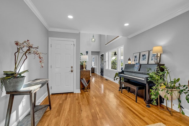 foyer with light wood-type flooring and crown molding