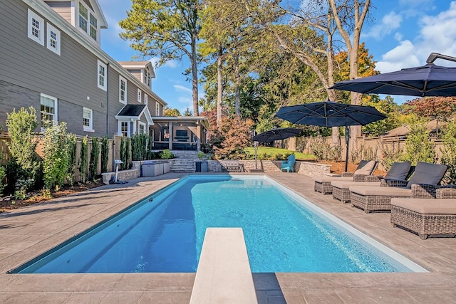 view of pool featuring a diving board, a patio area, and a sunroom