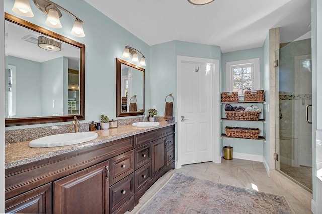 bathroom featuring a shower with shower door and vanity