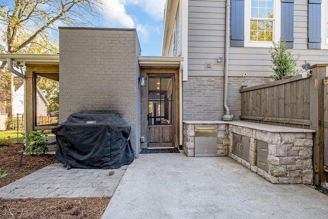 view of exterior entry featuring a patio area