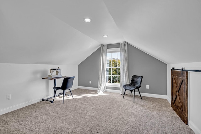 sitting room with light colored carpet, lofted ceiling, and a barn door