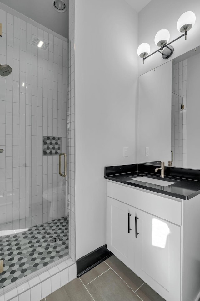 bathroom featuring vanity, tile patterned flooring, and a shower with door