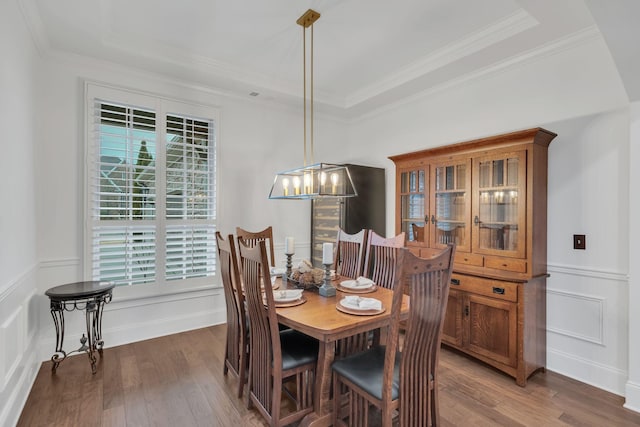 dining space featuring crown molding, dark hardwood / wood-style floors, and a tray ceiling