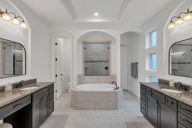 full bathroom featuring toilet, shower with separate bathtub, a raised ceiling, and vanity