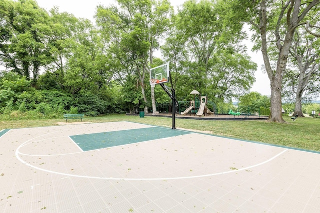 view of basketball court featuring a playground and a lawn