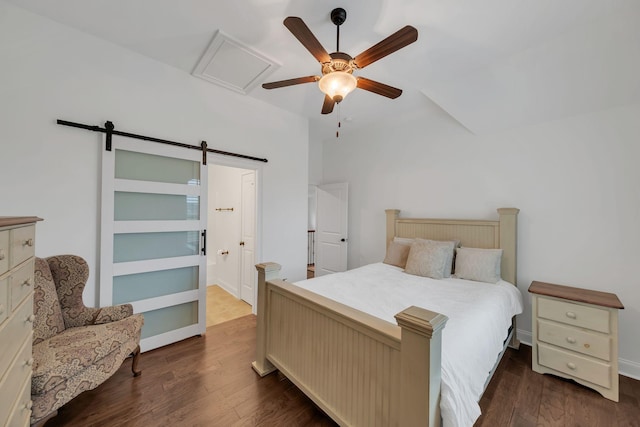 bedroom with ceiling fan, a barn door, and dark hardwood / wood-style floors