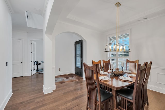 dining space featuring french doors, dark hardwood / wood-style floors, crown molding, and a notable chandelier