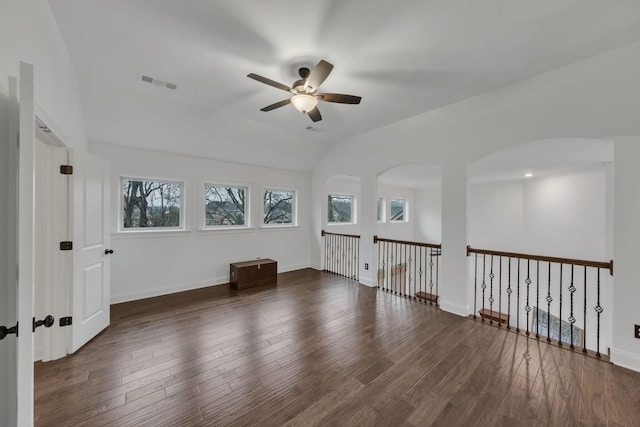 empty room with vaulted ceiling, ceiling fan, and dark wood-type flooring