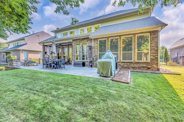 rear view of property featuring a lawn, ceiling fan, and a patio area