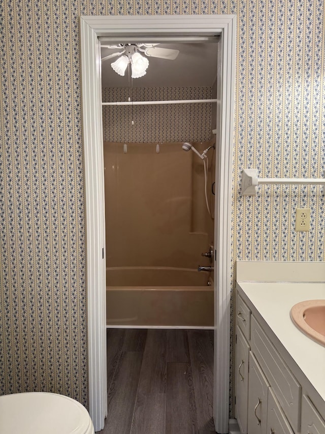 full bathroom featuring hardwood / wood-style floors, shower / bathing tub combination, vanity, ceiling fan, and toilet