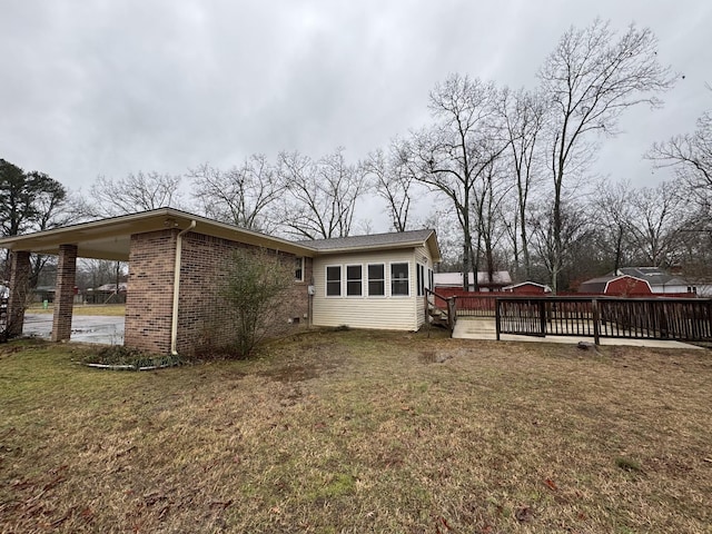 back of house with a sunroom and a lawn