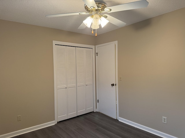 unfurnished bedroom featuring dark hardwood / wood-style flooring, ceiling fan, a closet, and a textured ceiling