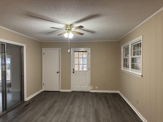 empty room featuring ceiling fan, crown molding, dark wood-type flooring, and a textured ceiling