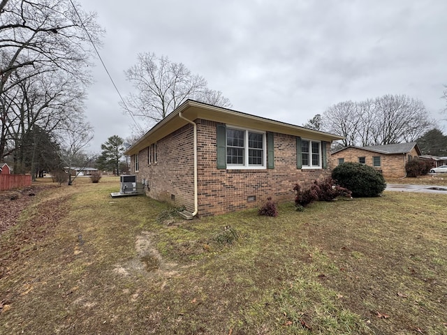 view of home's exterior featuring cooling unit and a lawn