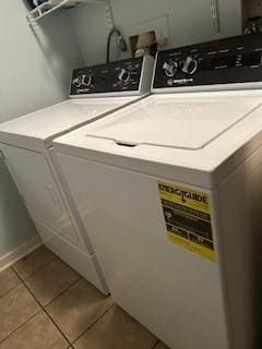 clothes washing area with light tile patterned flooring and independent washer and dryer