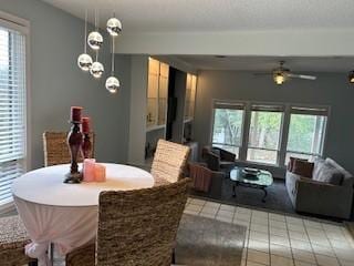 tiled dining space with a healthy amount of sunlight and ceiling fan