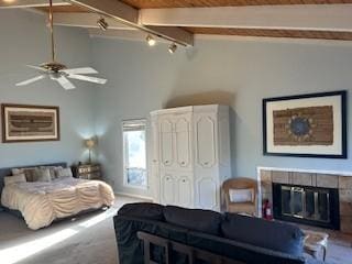 carpeted bedroom with beam ceiling, high vaulted ceiling, and a tile fireplace