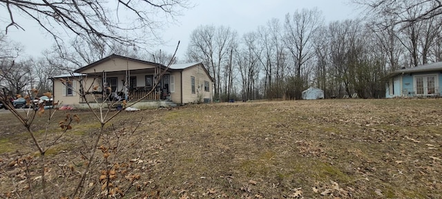 view of property exterior with a storage shed and a porch