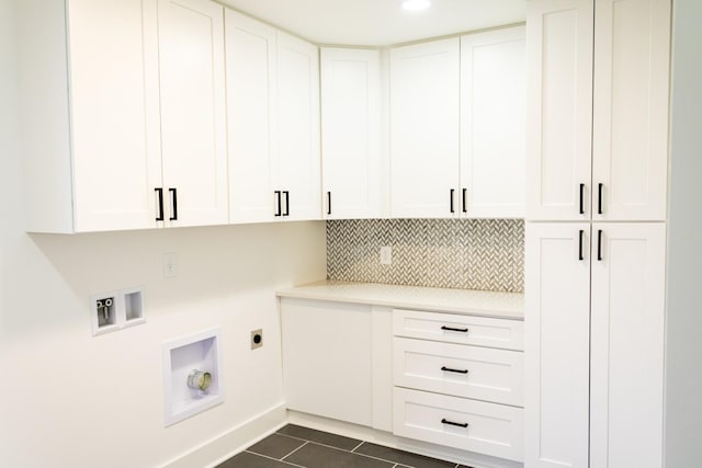 washroom with cabinets, washer hookup, dark tile patterned floors, and hookup for an electric dryer