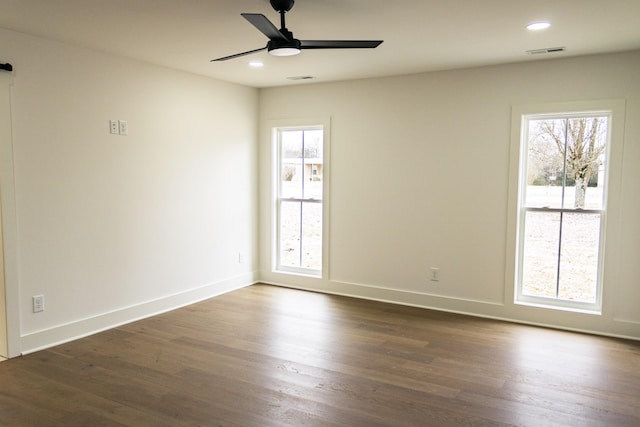 spare room featuring dark wood-type flooring and ceiling fan