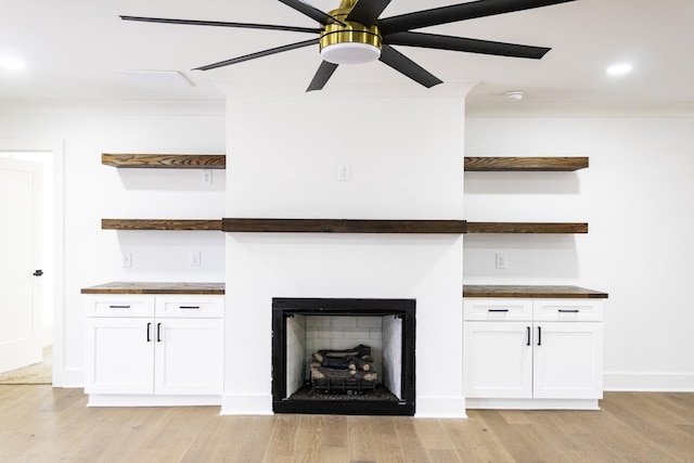 unfurnished living room with crown molding, ceiling fan, and light hardwood / wood-style floors