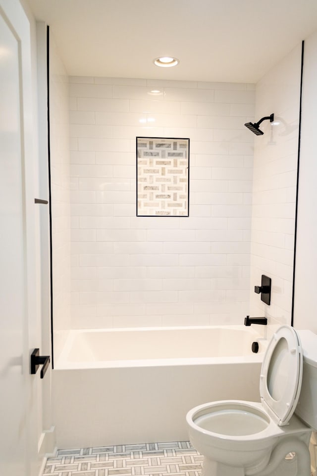 bathroom with tiled shower / bath and toilet