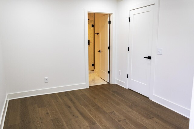 unfurnished room with dark hardwood / wood-style flooring