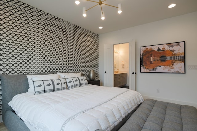 bedroom featuring ensuite bathroom and a chandelier