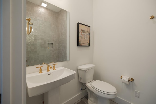 bathroom with toilet, tile patterned floors, and sink