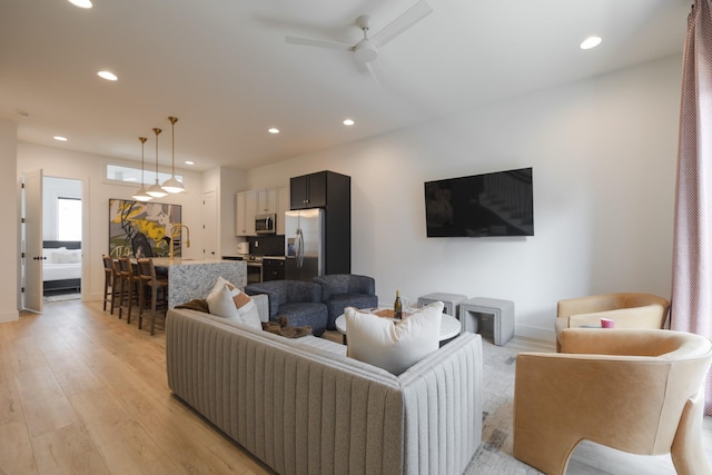 living room featuring ceiling fan and light hardwood / wood-style floors