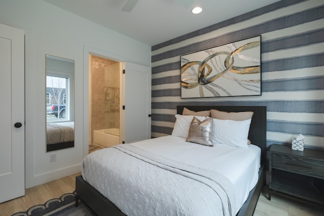 bedroom featuring ceiling fan, connected bathroom, and hardwood / wood-style flooring