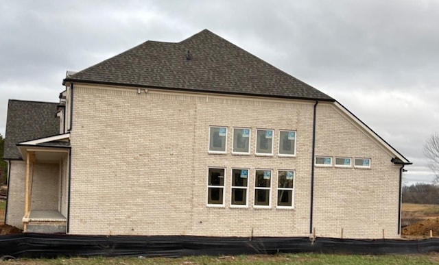 view of side of home featuring roof with shingles