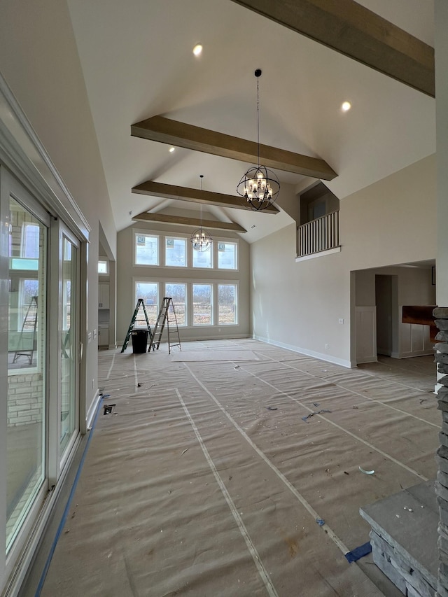 unfurnished living room featuring baseboards, a notable chandelier, high vaulted ceiling, beam ceiling, and recessed lighting