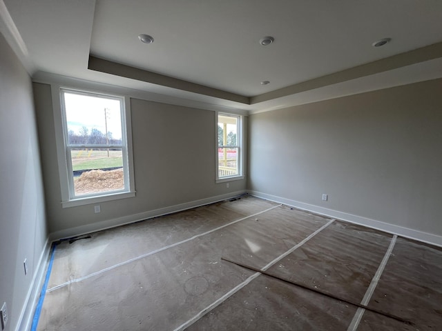 spare room featuring baseboards and a tray ceiling