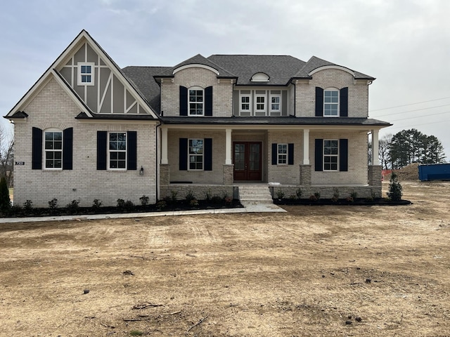 view of front of property with french doors, a porch, and brick siding