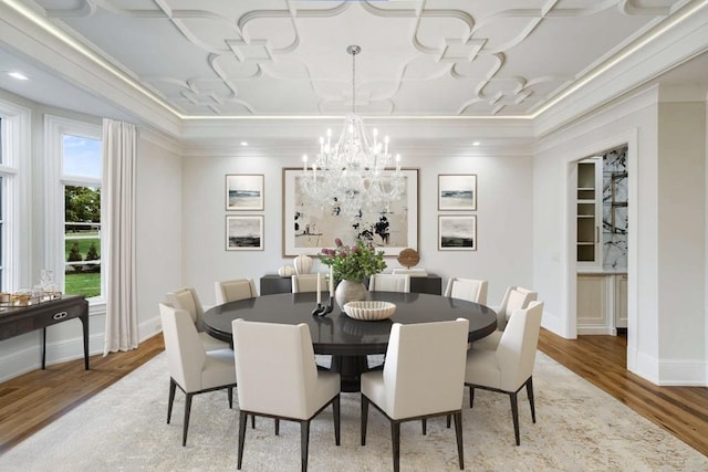 dining room with an inviting chandelier, crown molding, and wood-type flooring