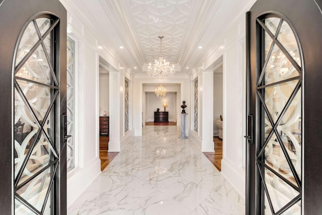 hall featuring a chandelier and crown molding